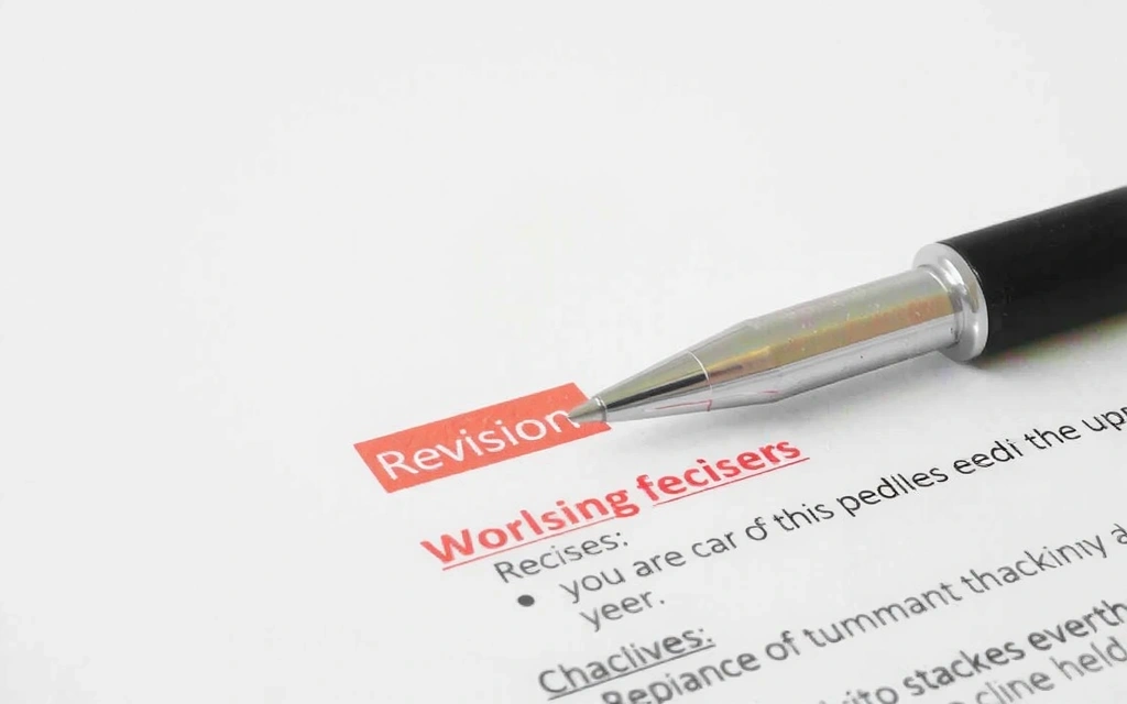 Document with revision marks and a pen